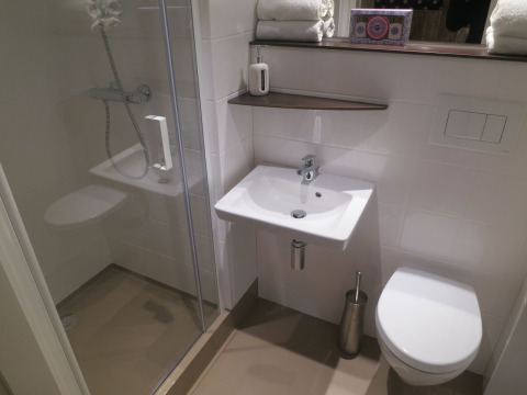 Moderne badeværelse i safaritelt med bruser, håndvask og toilet på Holiday park Eigen Wijze, Holland.