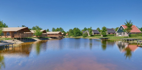 Tiendas safari y tiendas glamping junto a un lago en el parque vacacional Eigen Wijze en los Países Bajos.