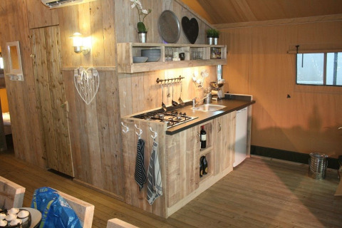 Cocina revestida de madera en una tienda de safari de lujo en Holiday Park Eigen Wijze, Países Bajos.
