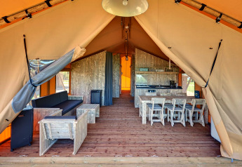 Interior view of a safari tent with rustic wooden furniture at Holiday park Eigen Wijze in the Netherlands.