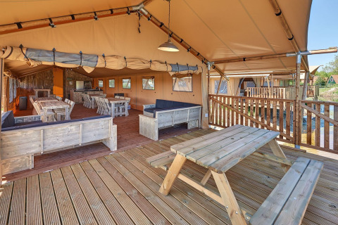 Vista interior de una tienda safari de lujo con muebles de madera en Holiday park Eigen Wijze, Países Bajos.