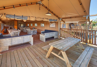 Vista interior de una tienda safari de lujo con muebles de madera en Holiday park Eigen Wijze, Países Bajos.