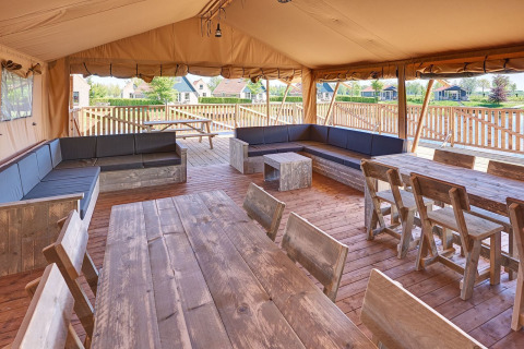 Grupo de tiendas safari con muebles de madera en Holiday park Eigen Wijze, Países Bajos.
