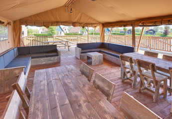 Indretning af en rummelig safariteltsgruppe med træmøbler i Holiday park Eigen Wijze, Holland.
