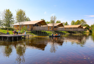Familias disfrutan junto al lago y tiendas glamping de lujo en Holiday park Eigen Wijze, Países Bajos.
