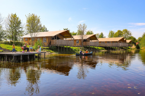 Famiglie si rilassano al lago vicino a tende safari di lusso all'Holiday park Eigen Wijze, Paesi Bassi.