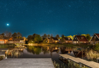 Notte stellata sul lago con tenda safari di gruppo e tende glamping di lusso a Holiday park Eigen Wijze, Paesi Bassi.