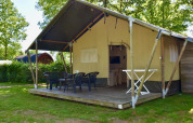 Tienda safari Comfort con terraza y sillas en Camping 't Veld, Países Bajos, rodeada de naturaleza.