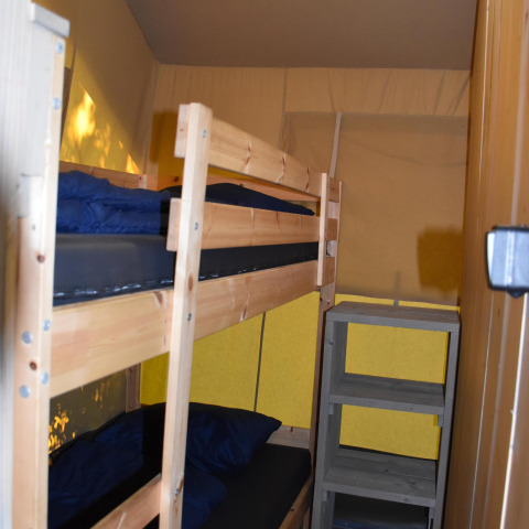 Et værelse med køjeseng og træreol inde i Comfort safari telt på Camping 't Veld i Nederlandene.