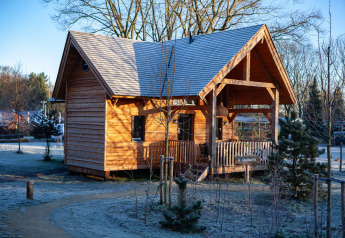 Houten lodge Heydehuis bij Sandberghe in Nederland, omgeven door een winters, berijpt landschap.