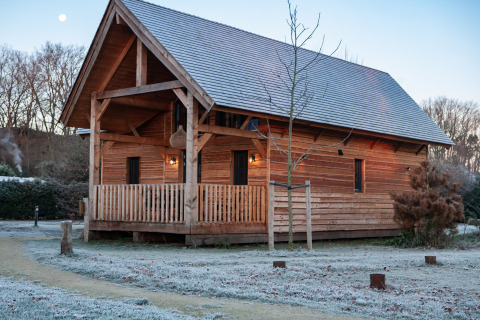Wooden lodge Heydehuis at Sandberghe in the Netherlands, with frost on the ground in early morning light.