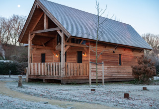 Wooden lodge Heydehuis at Sandberghe in the Netherlands, with frost on the ground in early morning light.
