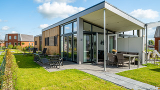 Tiny house moderne à Tusken de Marren, aux Pays-Bas, avec terrasse, jardin et grandes baies vitrées lumineuses.