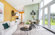 Salón y comedor modernos en Tiny House Knilles, con grandes ventanales, colores pastel y decoración elegante.