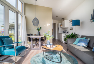 Interior luminoso y moderno de la tiny house Knilles en Tusken de Marren, Países Bajos, con detalles en azul.