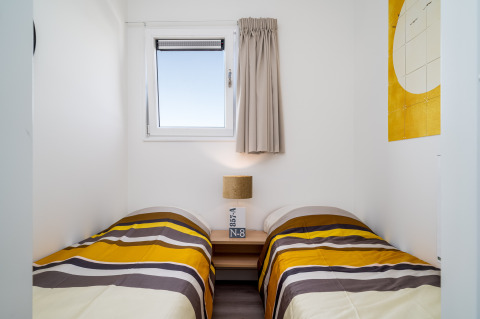 Pequeño dormitorio en Knilles, Tusken de Marren, Países Bajos, con dos camas individuales y decoración moderna.