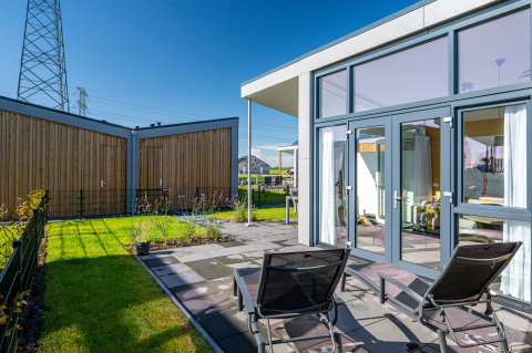 Modern tiny house Knilles at Tusken de Marren in the Netherlands, patio with sun loungers.