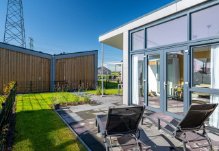 Modern tiny house Knilles at Tusken de Marren in the Netherlands, patio with sun loungers.