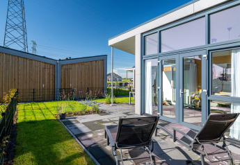 Tiny house moderne Knilles à Tusken de Marren, Pays-Bas, terrasse ensoleillée et transats.