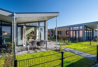Modernes Tiny House Knilles bei Tusken de Marren in den Niederlanden mit Terrasse und Gartenmöbeln.