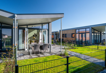 Tiny house moderne Knilles à Tusken de Marren, Pays-Bas, avec terrasse ensoleillée et mobilier d’extérieur.