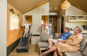 Gezin ontspant in een Stuuflodge safaritent met glijbaan bij Kampeerdorp de Zandstuve, Nederland.