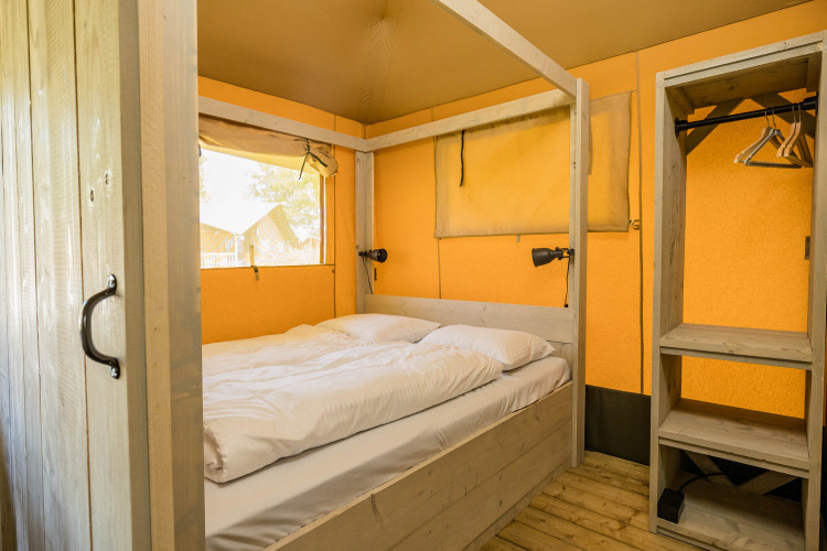 Slaapkamer in Stuuflodge safaritent op Kampeerdorp de Zandstuve in Nederland, met tweepersoonsbed.