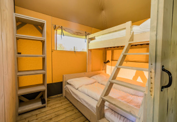 Camera con letto a castello e letto matrimoniale in una tenda safari Stuuflodge a Kampeerdorp de Zandstuve, Paesi Bassi.
