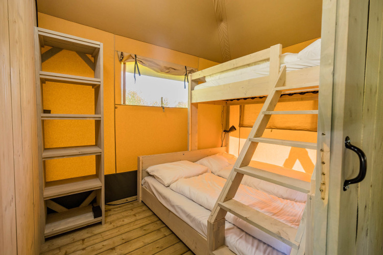 Slaapkamer met stapelbed en tweepersoonsbed in een Stuuflodge safaritent op Kampeerdorp de Zandstuve, Nederland.