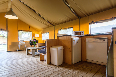 Vista interior de Stuuflodge Bella, una tienda safari con cocina en Kampeerdorp de Zandstuve en Países Bajos.