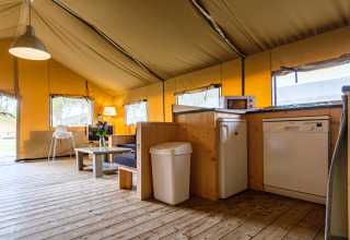 Vista interior de Stuuflodge Bella, una tienda safari con cocina en Kampeerdorp de Zandstuve en Países Bajos.
