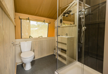 Baño con inodoro, ducha y lavabo en Stuuflodge DeLuxe, tienda safari en Kampeerdorp de Zandstuve, Países Bajos.