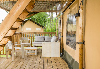 Udendørs terrasse med træmøbler ved Stuuflodge DeLuxe, safari telt på Kampeerdorp de Zandstuve, Holland.