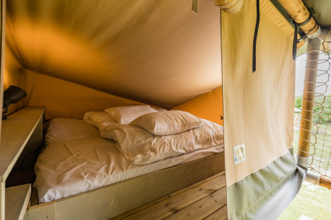 Vista interna di un letto accogliente nello Stuuflodge DeLuxe, tenda safari a Kampeerdorp de Zandstuve, Olanda.