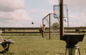 Jongen speelt voetbal aan een doelpaal in het gras nabij Ophemert, Gelderland, Nederland.