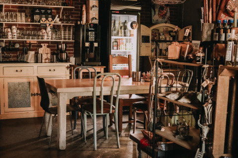 Acogedor interior de cafetería con mesas de madera en Feather Down Hoeve De Pippert, Gelderland, Países Bajos.