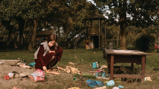 Una niña juega con juguetes en un arenero en un parque infantil rodeado de vegetación cerca de Ophemert, Países Bajos.