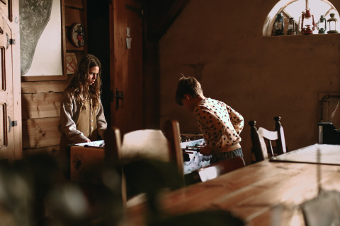 Two children playing in a cozy wooden house at Feather Down Hoeve De Pippert holiday park in Gelderland.