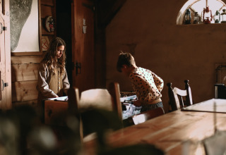 Due bambini che giocano in una casa di legno al Feather Down Hoeve De Pippert, parco vacanze in Gelderland.