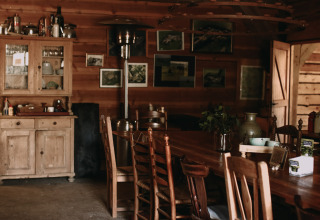 Acogedor interior de cabaña de madera con mobiliario rústico en Feather Down Hoeve De Pippert, Países Bajos.