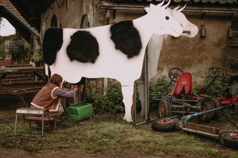 Niño ordeñando una vaca artificial en Feather Down Hoeve De Pippert, parque vacacional en Gelderland.