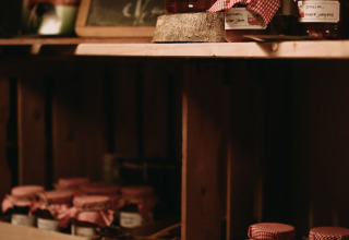 Hausgemachte Marmelade und Honig in Gläsern mit rotkarierten Deckeln im Feather Down Hoeve De Pippert.