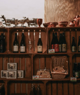 Estantes con botellas de vino, cerámica y productos locales en Feather Down Hoeve De Pippert, Gelderland.