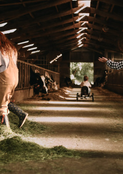 Niños juegan en un granero con heno fresco en Feather Down Hoeve De Pippert, parque vacacional en Gelderland, Países Bajos.