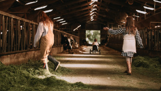 Niños juegan en un granero con heno fresco en Feather Down Hoeve De Pippert, parque vacacional en Gelderland, Países Bajos.