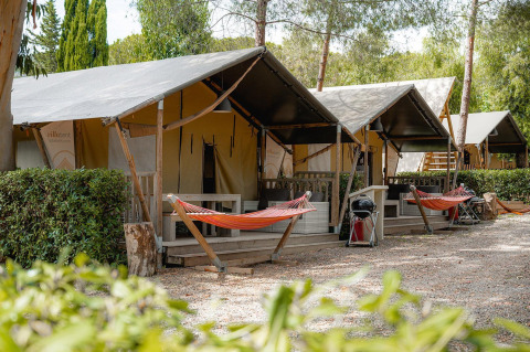 Safaritenten Villatent Nomad op Camping Casa dei Prati in Italië, omgeven door hangmatten en groen.