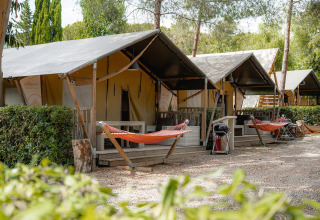 Safari tents called Villatent Nomad at Camping Casa dei Prati in Italy, featuring hammocks and lush greenery.