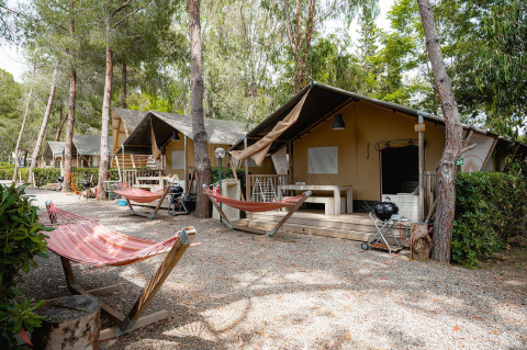 Safari tenten Villatent Nomad bij Camping Casa dei Prati in Italië, met hangmatten en zitplaatsen buiten.