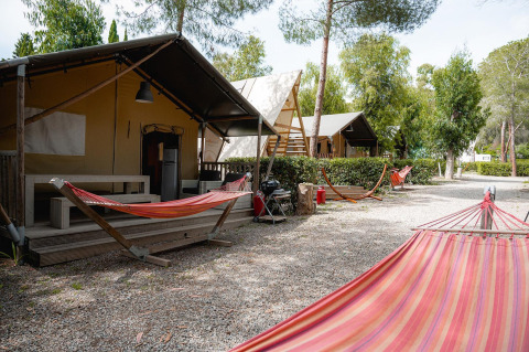 Safari tent Villatent Nomad op Camping Casa dei Prati in Italië, met hangmatten en bomen erbij.