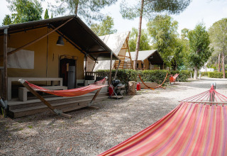 Safari tent Villatent Nomad op Camping Casa dei Prati in Italië, met hangmatten en bomen erbij.